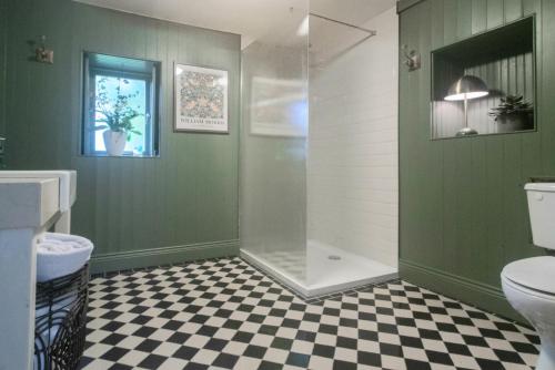 a bathroom with a shower and a checkered floor at Courtyard Cottages in Tralee