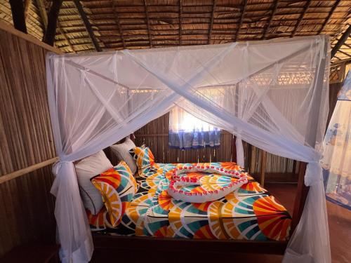 a bed in a room with a canopy at Bungalow Frédéric in Hell-Ville