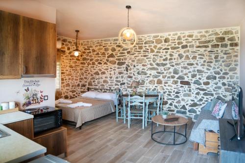 a kitchen and a living room with a stone wall at Oliva Mare II in Agia Fotia