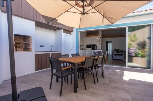 a kitchen and dining room with a table and chairs and an umbrella at São Jorge Holiday Homes in Velas