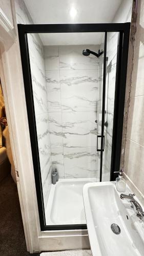 a bathroom with a white tub and a sink at Trinity House London Walthamstow in London