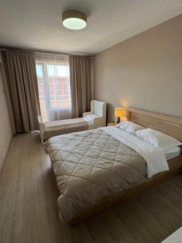 a bedroom with a bed and a chair and a window at Guest Apart Arda in Kŭrdzhali