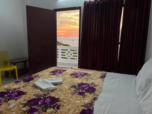 a bedroom with a bed with a view of the ocean at Hotel Paradise Kovalam in Trivandrum
