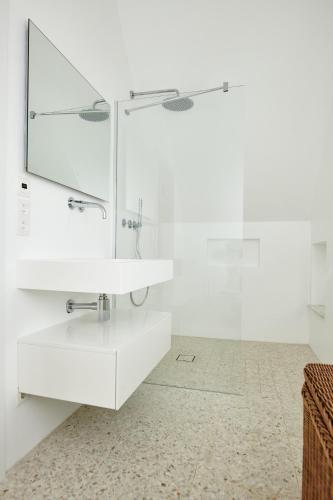 a white bathroom with a sink and a mirror at Seedorf Hideaway, Reethaus mit Garten und Privatsteg, Kamin, Sauna und Hot Tub in Ostseebad Sellin