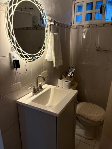a bathroom with a sink and a mirror and a toilet at Majen Nah in Progreso