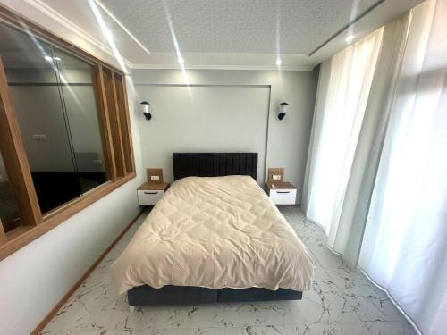a bedroom with a bed and a large window at Ande Tower studio in Minda