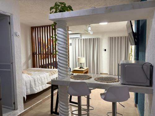 a living room with a table with chairs and a tv at Majen Nah in Progreso