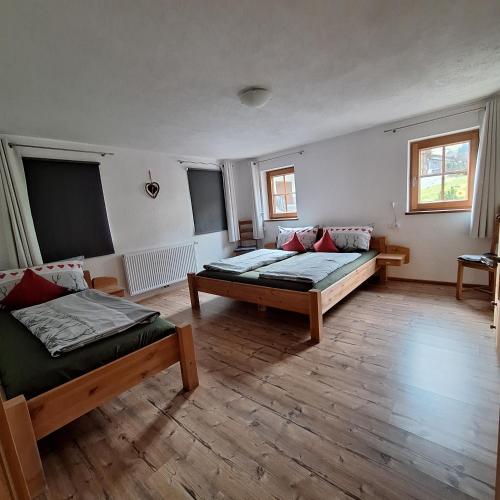 a large room with two beds and two windows at Haus Elfriede in Schwendau