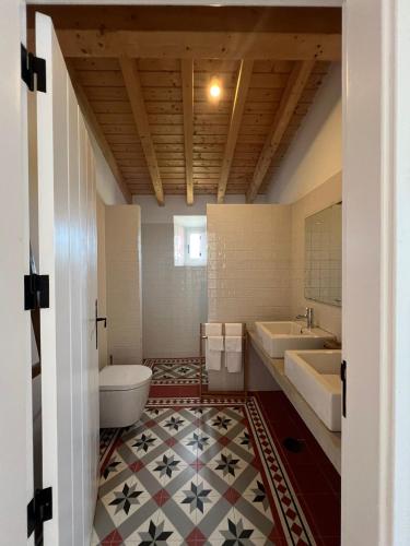 a bathroom with two sinks and a toilet and a tub at Marvão Country Houses - Queixos II in Santo António das Areias