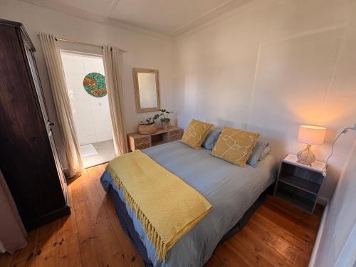 a bedroom with a bed and a window at Cosy Coastal Hideaway in Hermanus