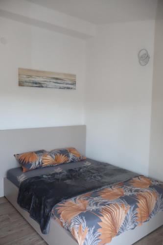 a bed in a white room with two pillows on it at Apartman SASHA in Bar