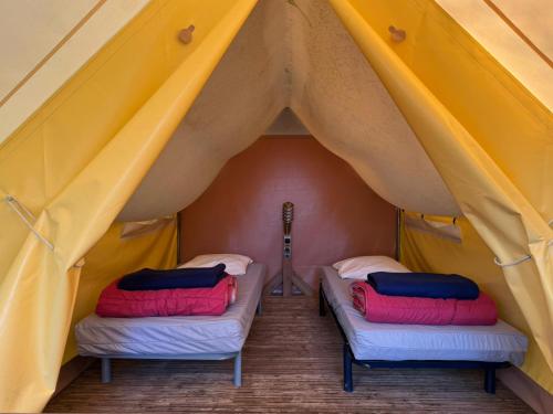 a tent with two beds in the middle at Camping Le Neptune in Lanloup