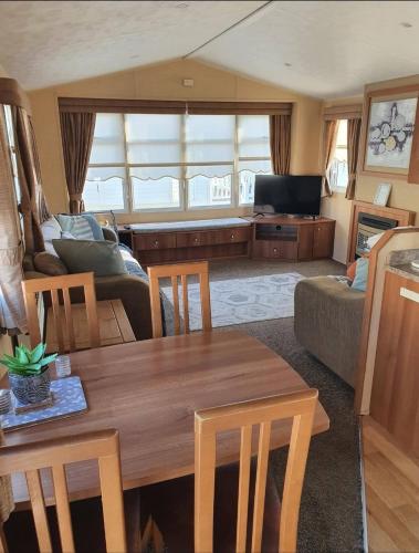 a living room with a table and a couch at Robin hood rhyl Ll18 3uu in Rhyl