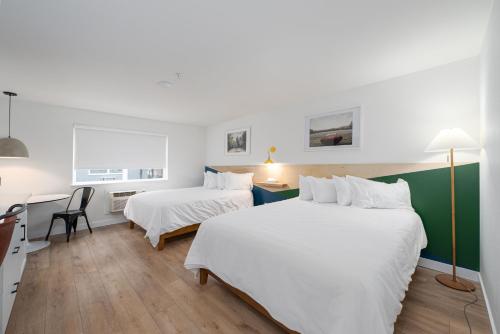 a bedroom with two beds and a desk with a chair at Varsity North in Centralia
