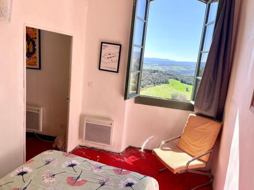 a bedroom with a bed and a large window at Balcon sur le Luberon in Lurs