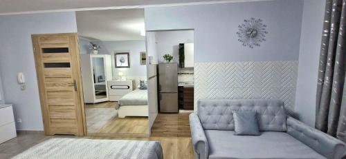 a living room with a couch and a refrigerator at Apartment GLAMOUR Downtown balcony FREE PARKING SPACE in Krakow