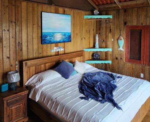 a bedroom with a bed with a wooden wall at SEGUNDA BRISA in Tucker Bight