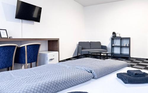 a bedroom with a bed and a tv and chairs at Hotel Central in Ostrava