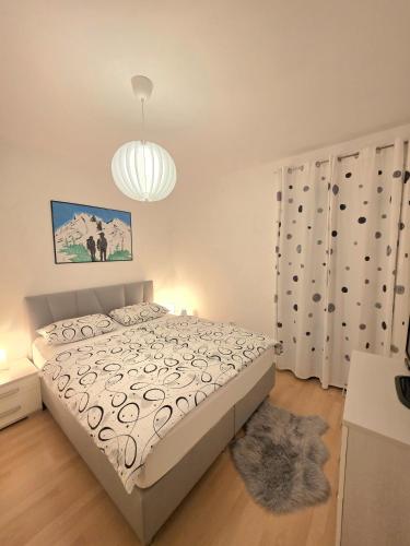 a bedroom with a bed and a chandelier at Apartma Katarina's place in Bovec