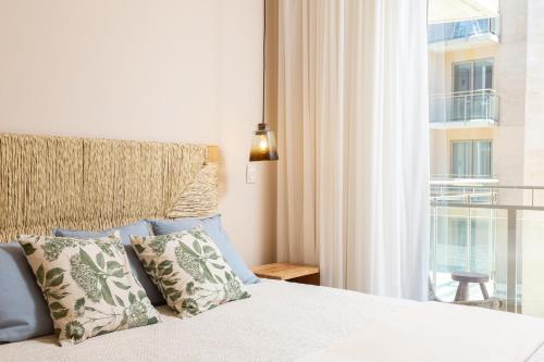 a bedroom with a bed with pillows and a window at Las Arenas de Cabo in Cabo San Lucas