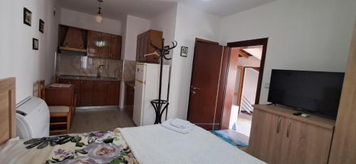 a room with a kitchen with a television and a table at Apartment near the Lake -Pogradec in Pogradec