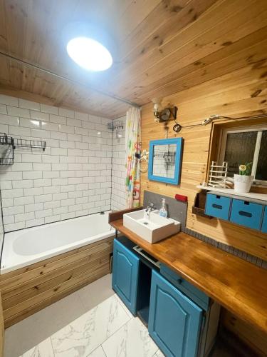 a bathroom with a tub and a sink and a bath tub at Domek Zacisze całoroczny in Świętne