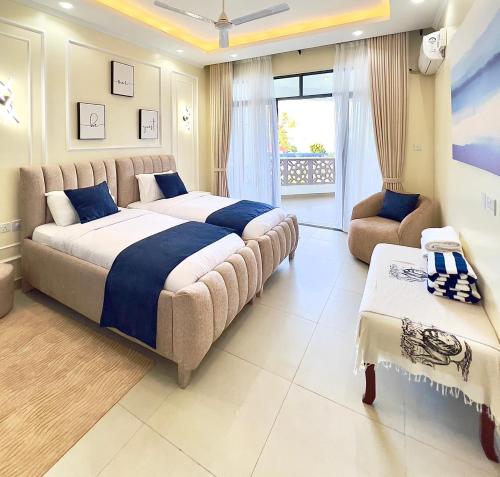 a large bedroom with a large bed and a couch at Luxury Beachfront apartment at Baobab Waves in Mombasa