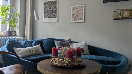 a living room with a blue couch and red candles at Ferienwohnung Sorgenfrei in Kurort Altenberg