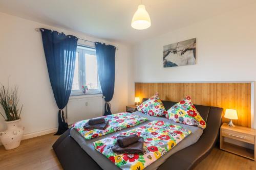 a bedroom with a bed and a window with blue curtains at Ferienwohnung Waldeck am Edersee in Waldeck