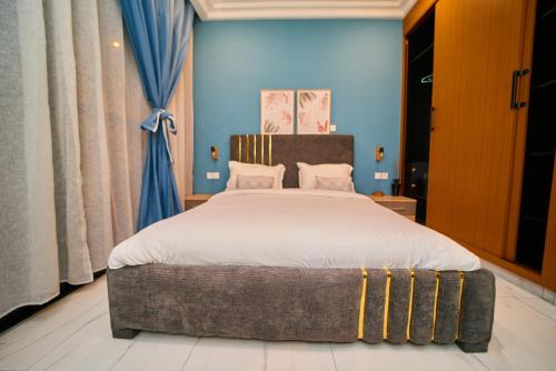 a bedroom with a large bed and blue walls at Résidence Akia - Jacuzzi privé & détente moderne in Pointe-Noire