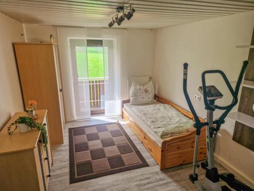 a small room with a bed and a treadmill at Ferienwohnung Osterberg in Unterthingau