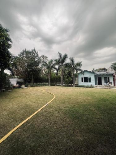 a large yard with a house and palm trees at CASA NOVA Villa in Noida