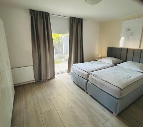 a bedroom with two beds and a large window at Apartments WK in Cologne