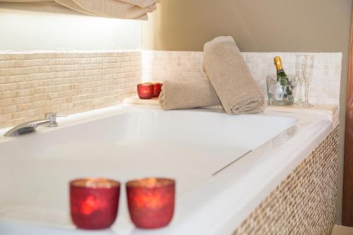 two red candles sitting on a bathtub in a bathroom at SWISS MORAIRA HOTEL - Adults only in Moraira