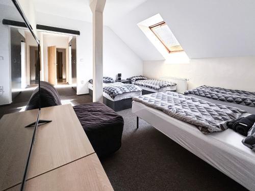 a room with three beds and a couch and a table at Apartmány Žalák in Ostrava