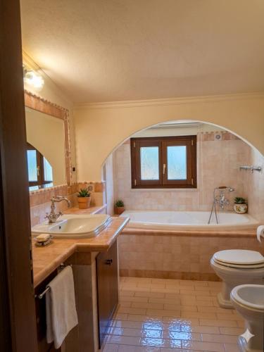 a bathroom with a tub and a sink and a toilet at Residence Martina in Marina di Camerota