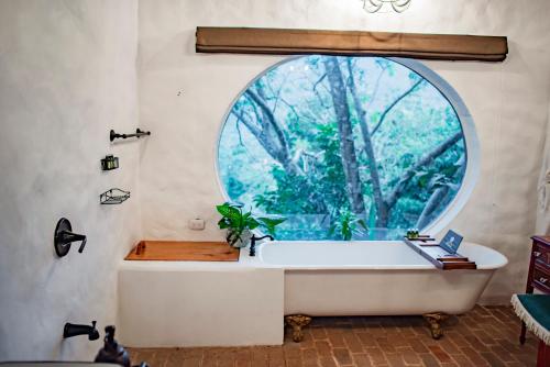 a bathroom with a tub with a large window at Hotel Don Ernesto By La Chimba in San José
