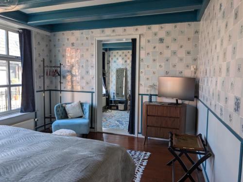 a bedroom with a bed and a chair and a mirror at De Tegel Suite in Anjum