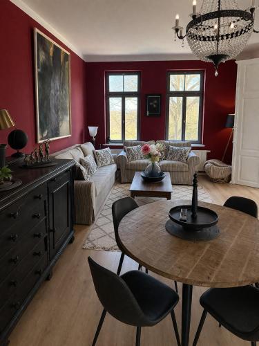 a living room with red walls and a table and chairs at Apartment Mare in Rostock