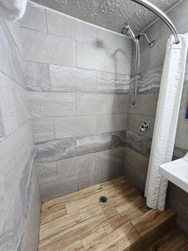 a shower with a wooden floor in a bathroom at Chek Inn Motel Rockingham NC in Rockingham