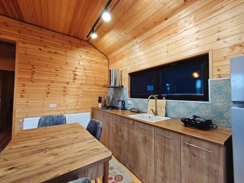a kitchen with wooden walls and a sink and a window at Pinewood Surami in Surami