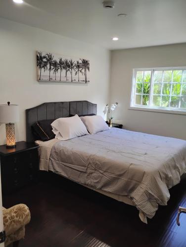 a bedroom with a large bed with palm trees on the wall at Cozy Suite near Universal Studios in Los Angeles