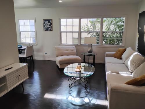 a living room with two couches and a glass table at Cozy Suite near Universal Studios in Los Angeles