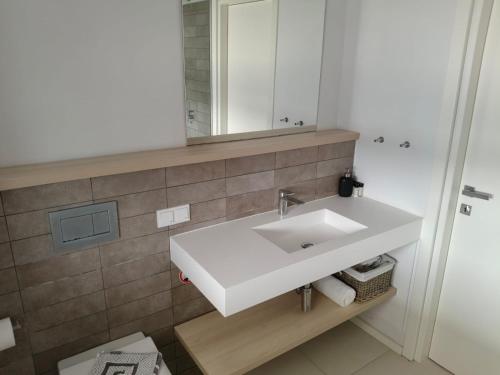 a bathroom with a white sink and a mirror at Villa Oikos in Syvota