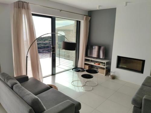 a living room with a couch and a large window at Villa Oikos in Syvota