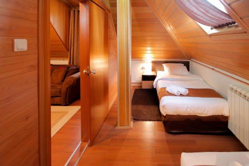 a small room with a bed in a small house at Hotel Junior in Kopaonik