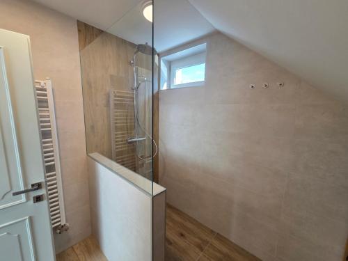 a bathroom with a shower with a glass door at Harmónia Apartmanház in Kőszeg