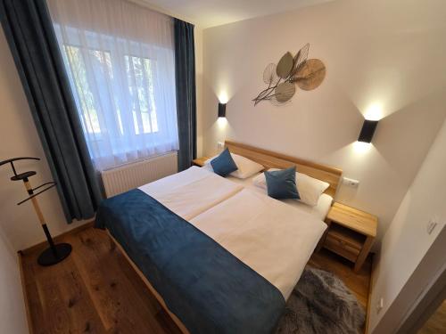 a bedroom with a bed and a large window at Harmónia Apartmanház in Kőszeg