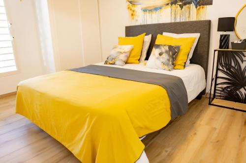 a bedroom with a large yellow bed with yellow pillows at Aimeelie - spacieux T3 avec piscine, terrasse, idéal famille, calme et lumineux in Lamentin