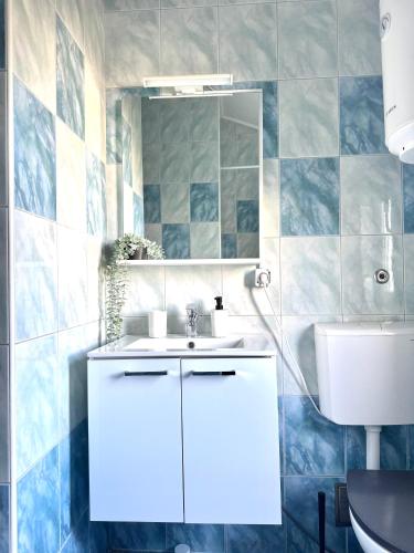 ein Badezimmer mit einem weißen Waschbecken und einem Spiegel in der Unterkunft Gold Apartment On The Beach in Novalja
